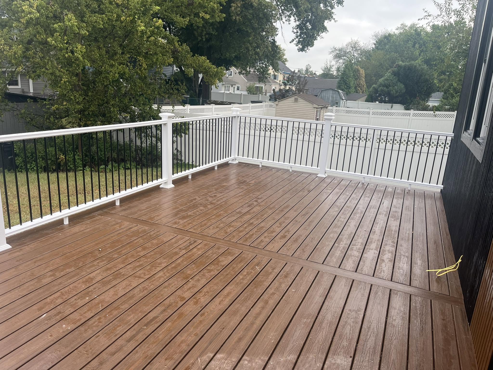 New composite deck with white railing and black aluminum balusters