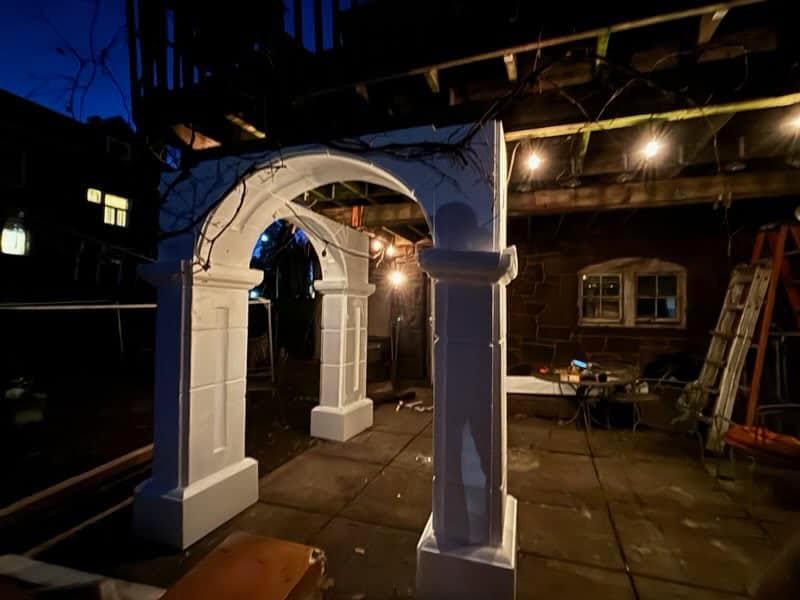 Installed white columns and arch on a residential patio at night
