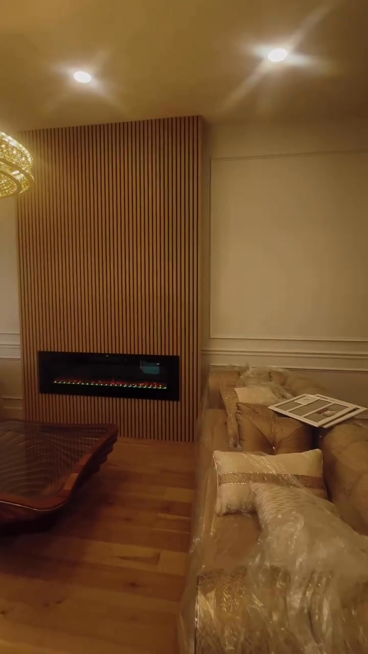 Wood slat feature wall with a built-in linear electric fireplace
