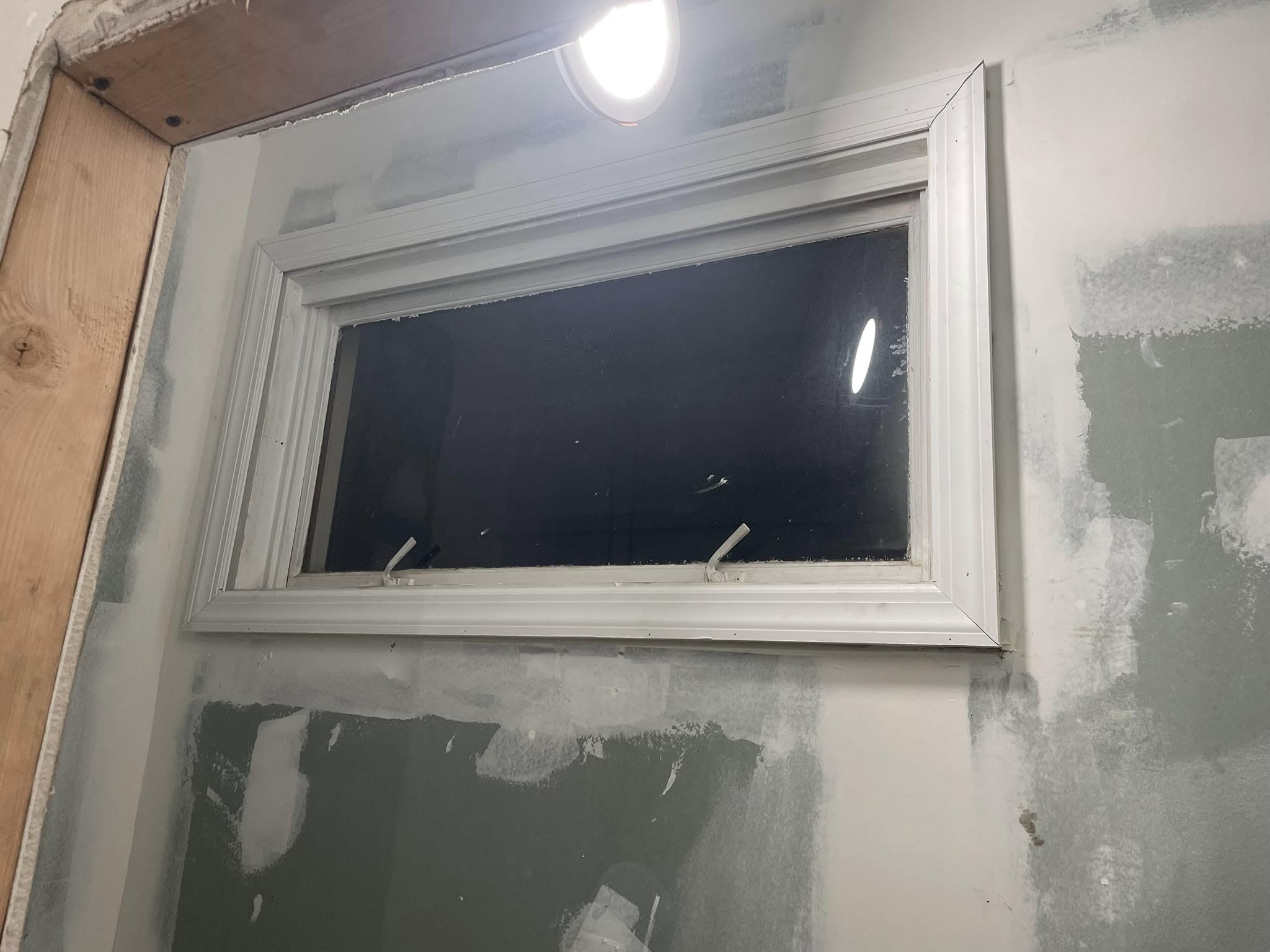 Newly installed window casing and trim against finished drywall
